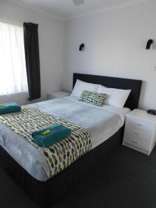梅林布拉梅林布拉湖公寓的一间卧室配有一张大床和两条毛巾