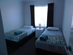 梅林布拉梅林布拉湖公寓的一间卧室设有两张床和窗户。