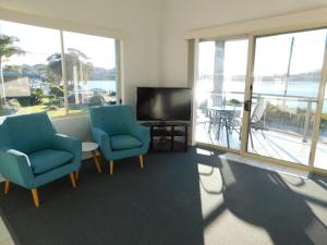 梅林布拉梅林布拉湖公寓的客厅配有两把椅子、电视和窗户。