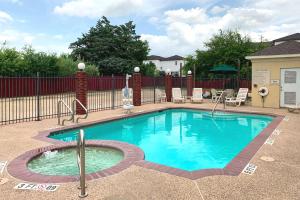 大学城德克萨斯大道舒适套房酒店的一个带围栏的院子内的游泳池