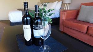 佩诺拉亚历山大卡梅隆套房汽车旅馆的客厅桌子上放着两瓶葡萄酒