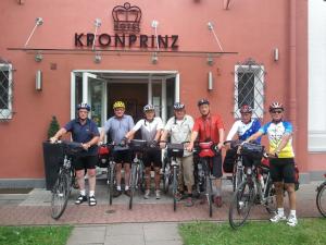 明登科隆帕丽泽咖尼酒店的一群人站在建筑物前面,骑着自行车