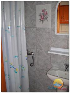 托罗尼DIALEKTI STUDIOS的浴室配有淋浴帘和盥洗盆。