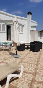 马略卡岛帕尔马Son Roqueta的房屋前设有带桌子和遮阳伞的天井。