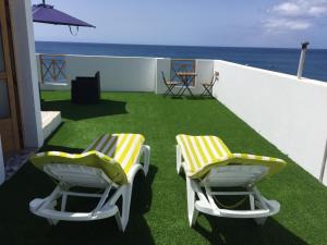 LajitaLa Lajita Ocean View 2的阳台上摆放着两把黄色和白色的椅子,享有海景