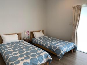 北谷町Kokoro no yado Mihama的一间卧室设有两张床和窗户。