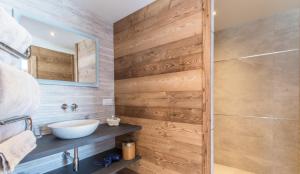 里雾诗chalet des grands bois的一间带水槽和木墙的浴室