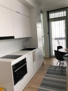 奥卢Beautiful apartment at Toppilansalmi的厨房配有白色橱柜和桌子