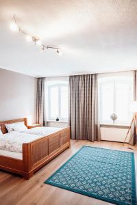 特劳恩施泰因Ferienwohnung Stadtplatz 25的一间卧室配有一张大床和蓝色地毯。