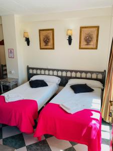 马贝拉阿杜阿尔旅馆的红色床单的客房内的两张床