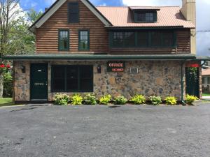 旧福奇Pine Knoll Hotel Lakeside Lodge & Cabin的一座带车库的石头建筑