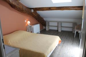 Saint-Sylvestre-sur-LotGITE clodeguy的卧室配有1张床、1张桌子和1把椅子