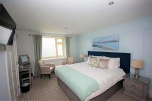 瓦特维尔Seaclusion Luxury Guest Accommodation的一间卧室配有一张床、一张书桌和一台电视