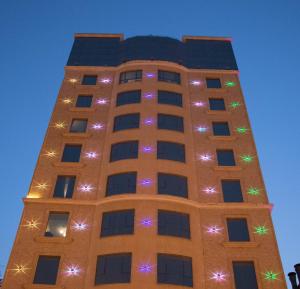 阿可贺巴Durrat Manzli ApartHotel的一座高大的建筑,上面有圣诞灯