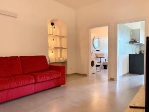蒙泰卢波菲奥伦蒂诺House of Arts的一间带红色沙发的客厅和一间厨房