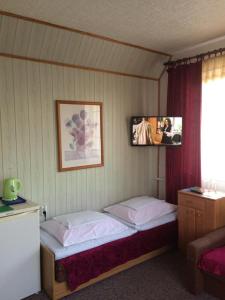梅尔诺Pokoje Gościnne的一间卧室设有两张床,墙上配有电视。