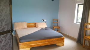 MimpassemHotel Belair KAFLAND的一间卧室配有一张带蓝色墙壁的木床