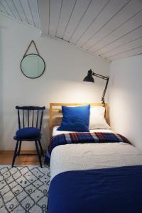 新松奇RowerowyFun的一间卧室配有一张床、一把椅子和一盏灯