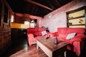 蒂哈拉费Casa Elena的客厅配有2把红色椅子和桌子