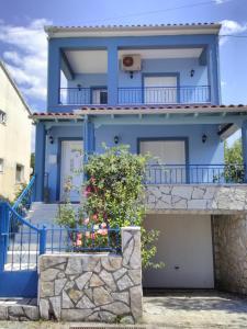 PlisioíMaisonette Ilios的蓝色的房子,设有阳台和鲜花