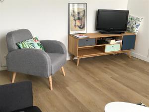 拉罗谢尔Appartement Saint-Nicolas的客厅配有电视和椅子