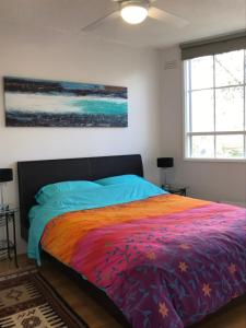 CarnegieSanta Monica Apartment的一间卧室配有一张带彩色毯子的床