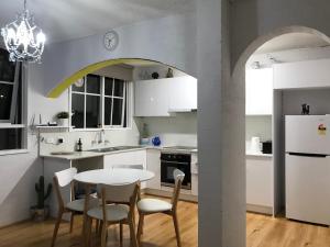 CarnegieSanta Monica Apartment的厨房配有白色橱柜和桌椅