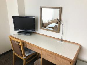 一宫市一宫绿色酒店的客房设有一张带电视和镜子的书桌