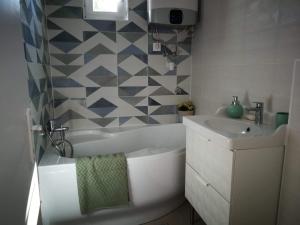 扎马迪Fűszerkert vendégház的浴室配有盥洗盆、浴缸和盥洗盆