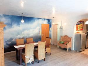 瓦尔兴湖Ferienwohnung Royal Walchensee的一间用餐室,墙上挂着云彩壁画,配有一张桌子