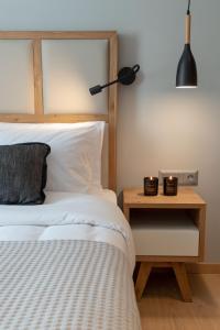 塞萨洛尼基Grand Port Suites的一间卧室配有一张床和一个带台灯的边桌
