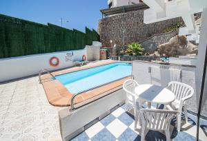 波多黎各Apartamentos Monte Verde的庭院中一个带桌椅的游泳池