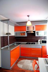 尼古拉耶夫Moskovskaya studio的厨房配有橙色橱柜和炉灶。