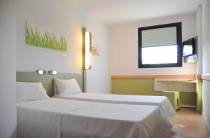 赫罗纳赫罗纳布拉瓦海岸宜必思快捷酒店的酒店客房设有两张床和窗户。