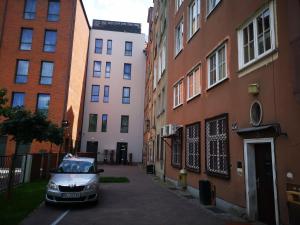 格但斯克德尔盖公寓酒店的停在建筑物旁的街道上的汽车
