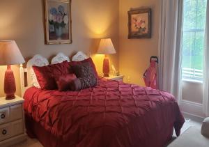皮克顿Harrington House Picton的一间卧室配有一张红色的床、两盏灯和一扇窗户。