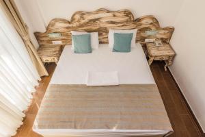 居姆贝特棉花酒店的一间卧室配有一张带蓝色枕头的大床