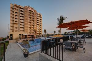 拉斯阿尔卡麦City Stay Beach Hotel Apartments - Marjan Island的一个带游泳池、桌子和遮阳伞的度假村