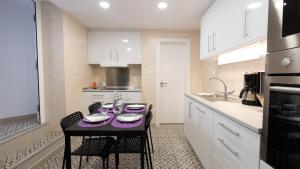 奥良Casa das 3 Andorinhas的厨房配有一张桌子,上面有紫色的桌布