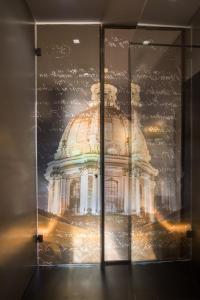罗马圣卡罗套房酒店的玻璃展示箱中建筑物的反射