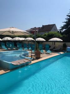 皮耶什佳尼戴安娜旅馆的一个带椅子和遮阳伞的游泳池