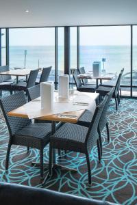 金斯科特Aurora Ozone Hotel Kangaroo Island的一间带桌椅的海景餐厅
