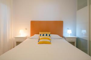 塞博河畔卡莱塔APARTAMENTO LOS REMOS DE LA GRACIOSA的一间卧室配有一张带两盏灯的大型白色床。
