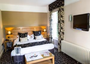 普里茅斯圣伊丽莎白酒店的配有一张床和一台平面电视的酒店客房