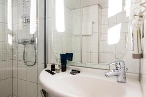 巴德胡弗多普阿姆斯特丹史基浦机场宜必思酒店的一间带水槽、镜子和淋浴的浴室