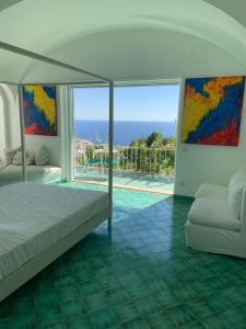 阿纳卡普里Il Carrubo Capri的一间卧室配有一张床,享有海景