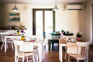 奥西莫Sottocastello Il Casale的一间设有白色桌椅的用餐室