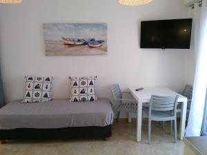 纳克索乔拉Infinity Apartments的一间卧室配有一张床、一张桌子和一台电视。