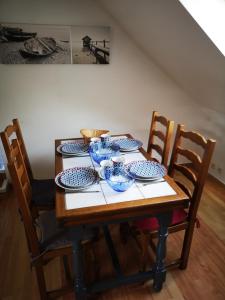 KerborsGîte Lézardrieux的一张木桌,上面有蓝色和白色的菜肴