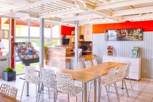 马孔Brit Hotel Macon Nord Autoroute du Soleil的一间带木桌和椅子的用餐室